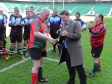 Mike Penning is presented with a bottle of champaign as 'Man of the Match' at the annual Commons & Lords charity rugby event